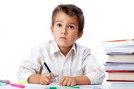 Portrait of a little schoolboy drawing  