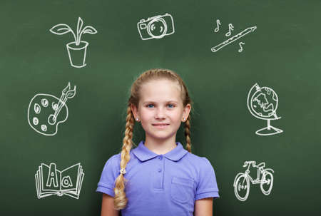 Portrait of smart girl by the blackboard looking at cameraの写真素材