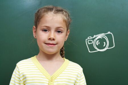 Portrait of smart lad by the blackboard looking at cameraの写真素材