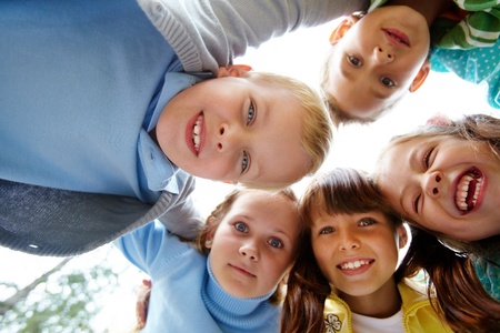 Portrait of happy friends looking at camera with cute boy in frontの写真素材