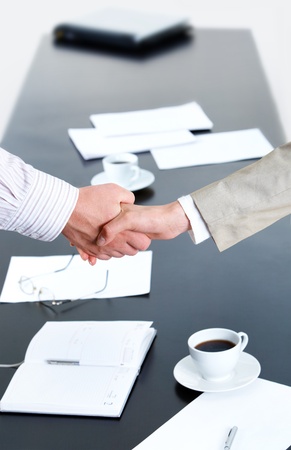 Image of business people shaking hands over workplaceの写真素材