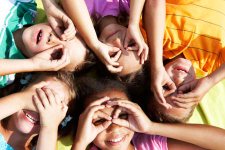 Portrait of happy preschoolers lying and looking at cameraの写真素材