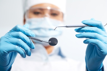Image of assistant in medical uniform holding dentistry tools in handsの写真素材