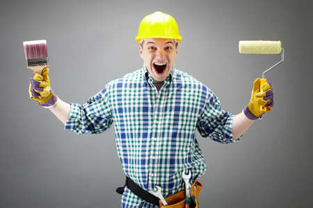 Portrait of crazy painter with paintbrush and rollerの写真素材