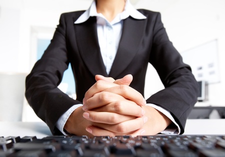 Photo of secretary with crossed fingers of both hands の写真素材