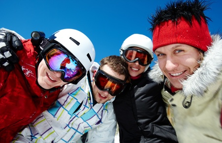 Portrait of happy company of guys and girl in googles looking at cameraの写真素材