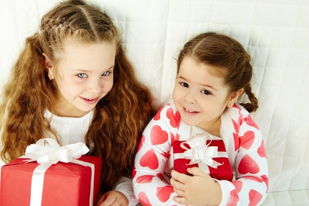 Portrait of happy girls with gifts looking at camera and smiling   の写真素材