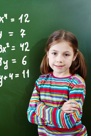 Portrait of pretty girl by the blackboard looking at cameraの写真素材