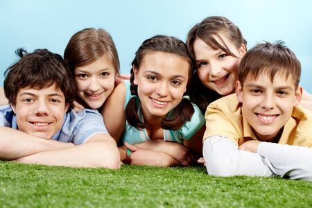 Portrait of five lying friends looking at camera and smilingの写真素材