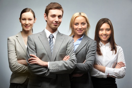 Portrait of four confident businesspeople looking at camera and smilingの写真素材