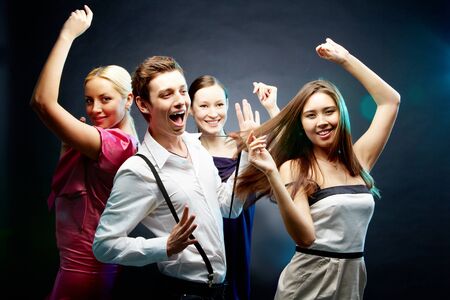 Four joyful friends dancing together