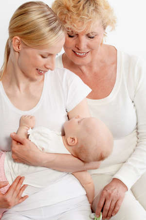 Portrait of two women looking at sleeping baby in mother hands