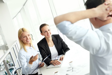 Portrait of confident businesswomen sharing ideas with colleague at meetingの写真素材
