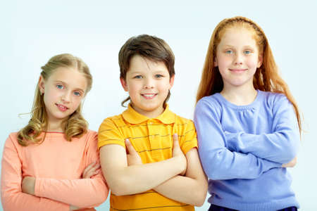 Portrait of smart schoolgirls and schoolboy looking at camera