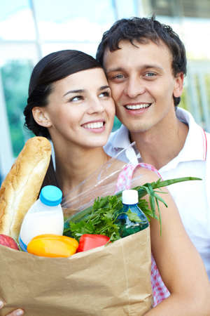 Portrait of a happy couple with foodstuff の写真素材
