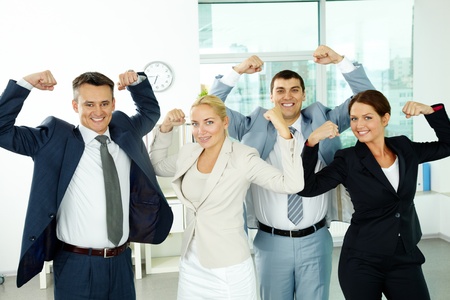 Portrait of business partners posing in front of camera showing their strengthの写真素材