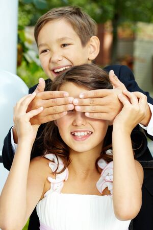 Portrait of laughing boy groom shutting eyes of his cheerful brideの写真素材