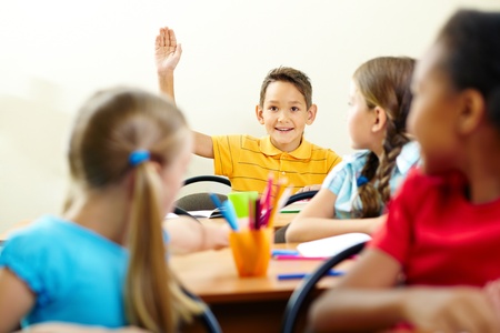 Image of smart pupil raising arm during the lesson の写真素材