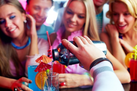 Photo of barman hand holding bottle and pouring water out of itの写真素材