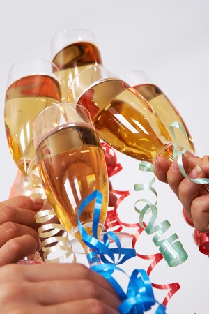 Close-up of flutes of golden champagne being clinked during toastの写真素材
