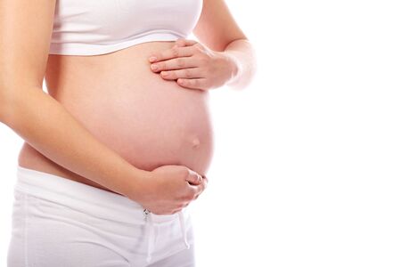 Close-up of pregnant woman touching her belly with hands