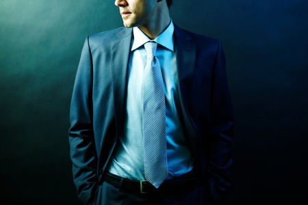 Figure of elegant businessman in suit posing in darknessの写真素材