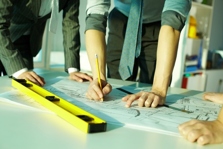 Three pairs of hands sketching a housing project