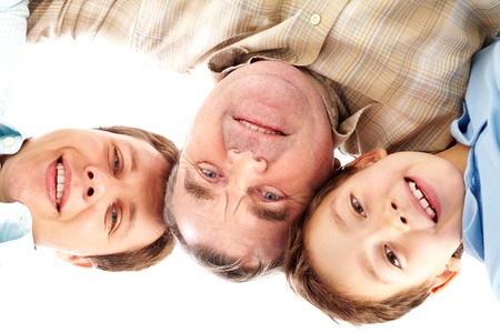Multigenerational portrait of male members of the family smiling and looking down at cameraの写真素材