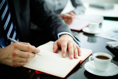 Image of male hand with pen over open notebook during planning workの写真素材