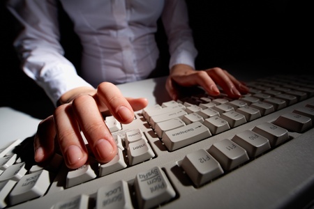 Image of human hands pressing keys of keyboard