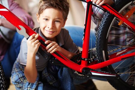 Portrait of cute boy with bicycle looking at cameraの写真素材