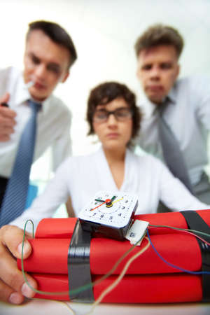 Close-up of dynamite with group of businesspeople on background 