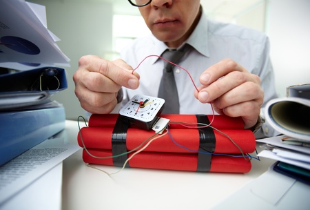 Close-up of businessman preparing bomb in office の写真素材