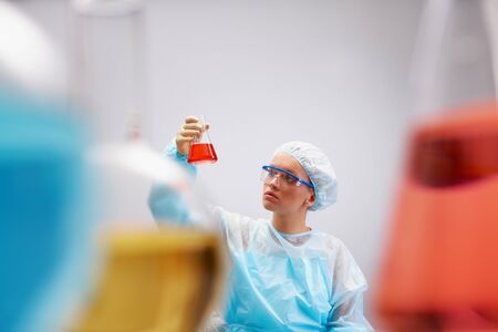 Portrait of female scientist holding medical tube with liquidの写真素材