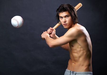 Image of shirtless man with baseball bat going to hit ballの写真素材