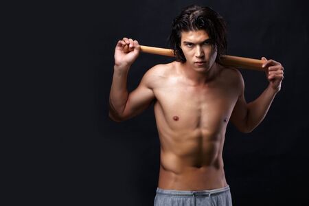 Image of shirtless man with bat looking at cameraの写真素材