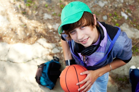 The above view of a smiling teen boy holding a basket-ballの写真素材