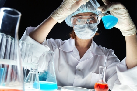 Surprised researcher studying the substance in a beakerの写真素材