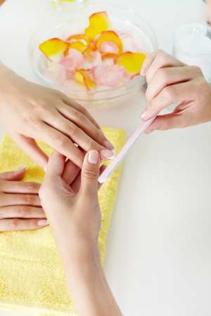 Hand care industry worker filing female nailsの写真素材