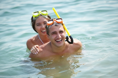 Young divers in scuba masks enjoying themselves in waterの写真素材