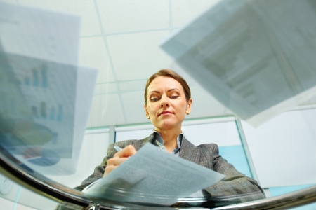 Business woman viewed from below signing documents and working with papersの写真素材