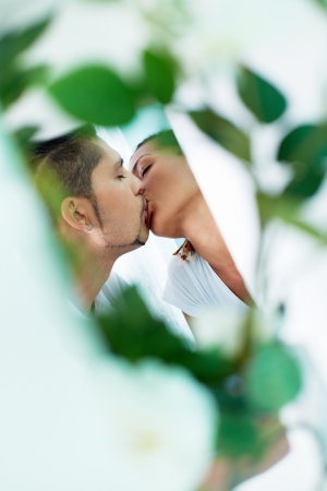 Young guy and his girlfriend sharing passionate kissの写真素材