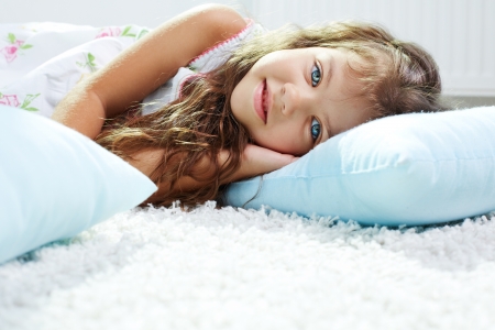 Portrait of lovely girl lying on pillowの写真素材