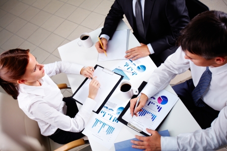 Young office workers discussing papers at meeting の写真素材