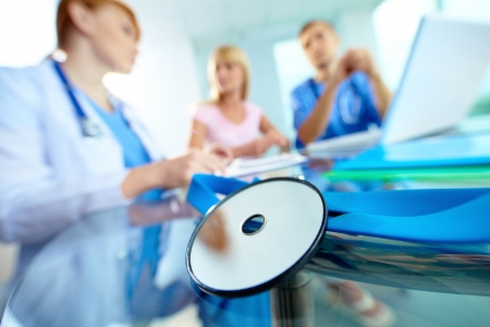 Close-up of medical equipment on background of doctors and patient working with laptopの写真素材