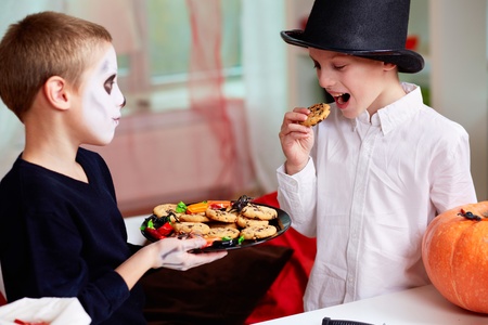  two eerie boys eating cookies on Halloween dayの写真素材