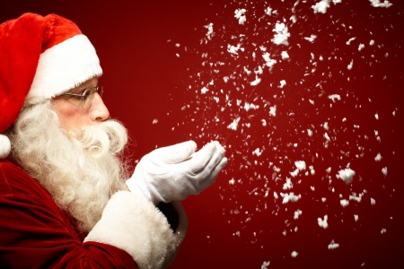 Photo of Santa Claus blowing snow and looking at itの写真素材