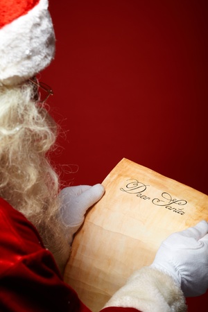 Image of Santa Claus reading Christmas letter in his handsの写真素材