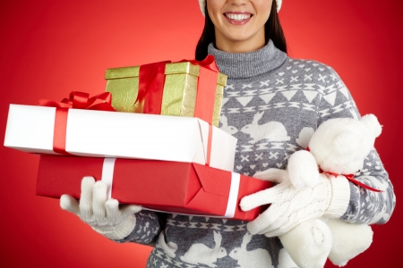 Close-up of happy girl with stack of giftboxes and white teddyの写真素材