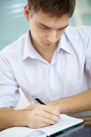 Portrait of young businessman making notes in notepadの写真素材